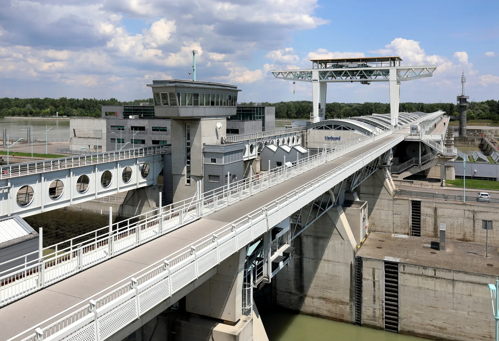 Modern concrete hydroelectric weir structure and lock complex across the Danube river in Vienna.