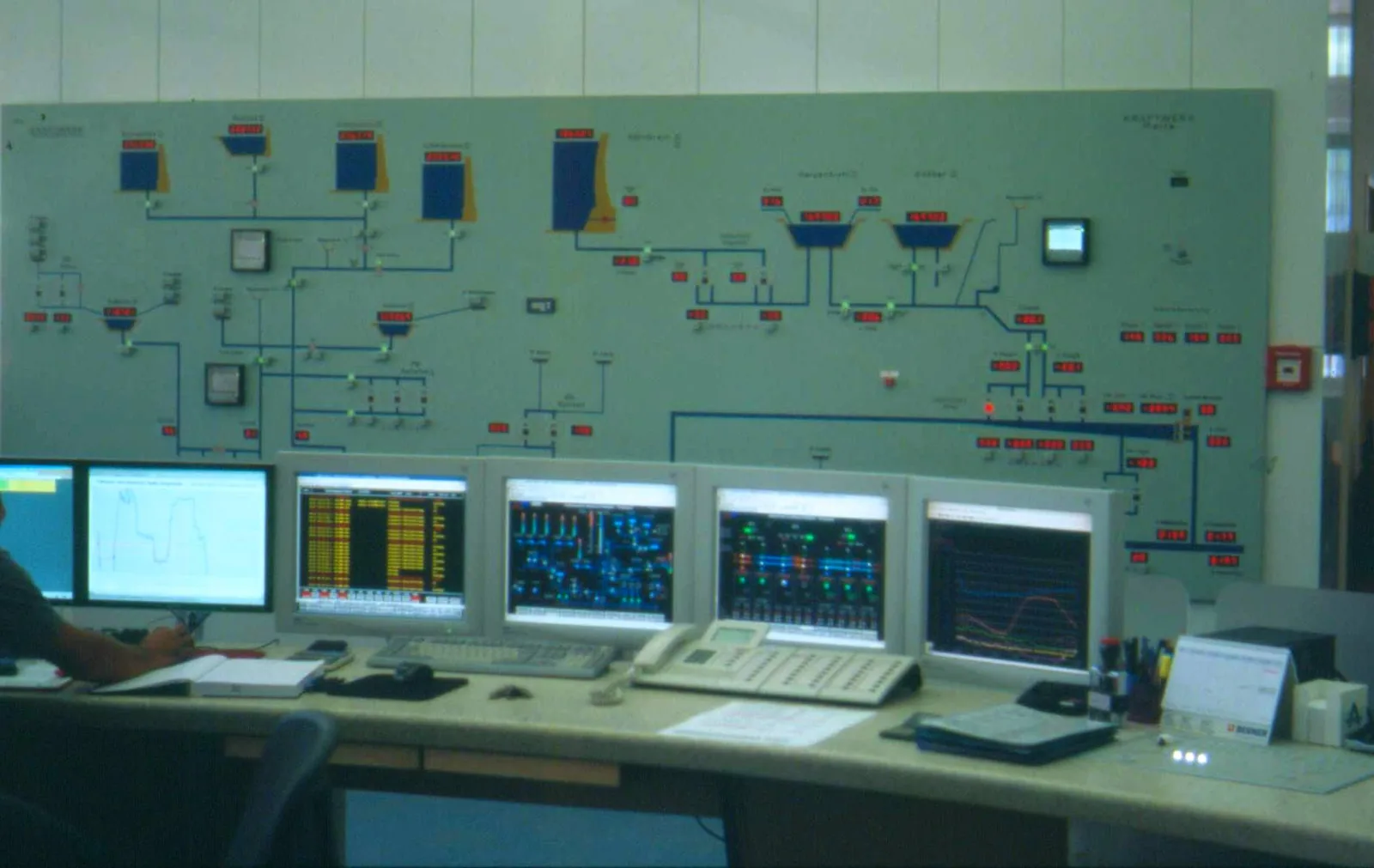 Spacious industrial machine hall housing electric generators and hydraulic turbine machinery inside an alpine power station.