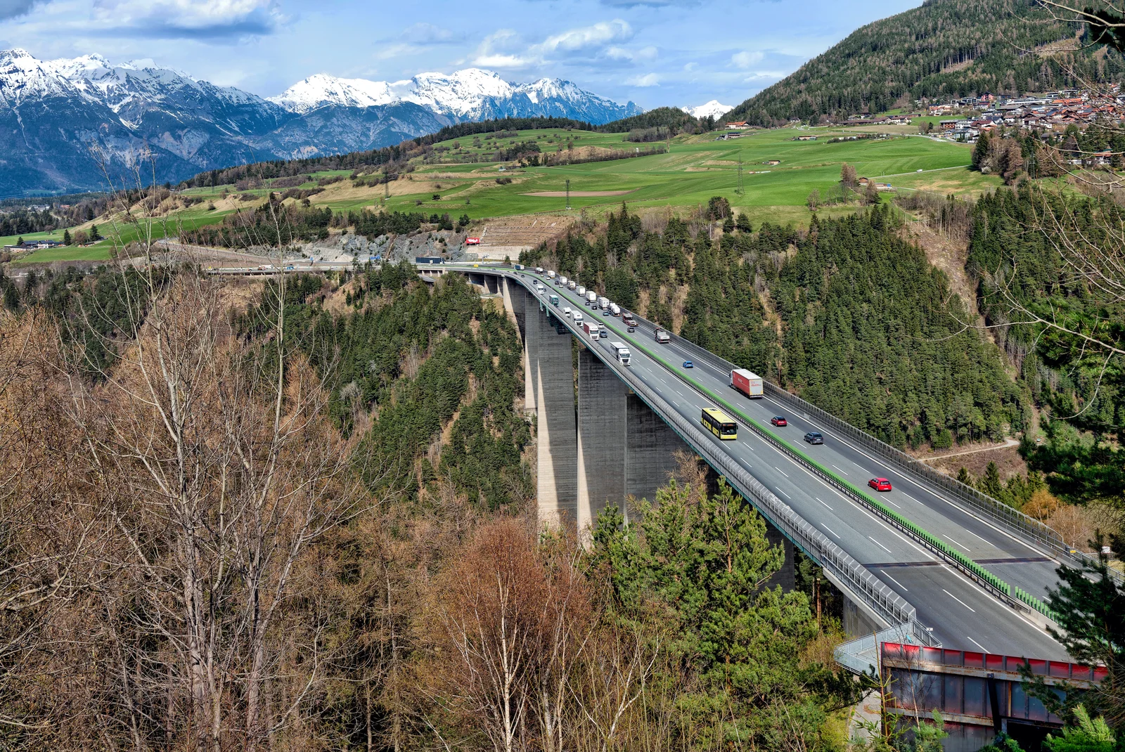 Soaring concrete highway bridge spanning an immense alpine valley gorge between mountain ridges in Tyrol.