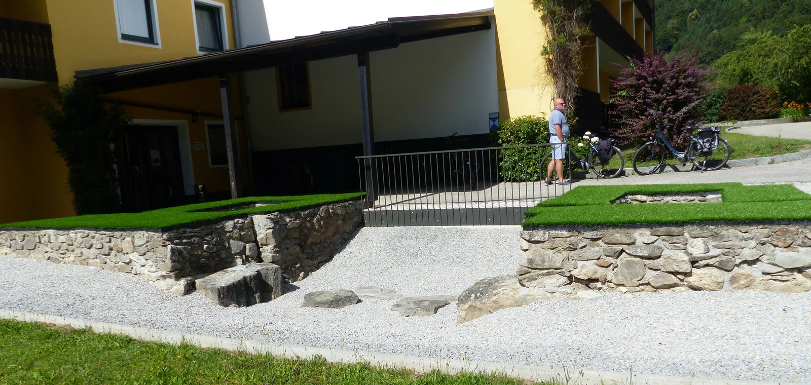 Conserved Roman stone gate foundations with information panels near the forested banks of the Danube River.