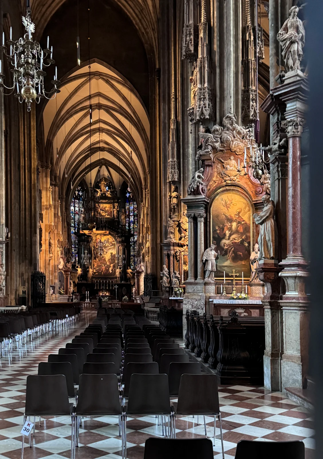 Gothic vaulted nave of St. Stephen's Cathedral leading to the illuminated high altar in Vienna.