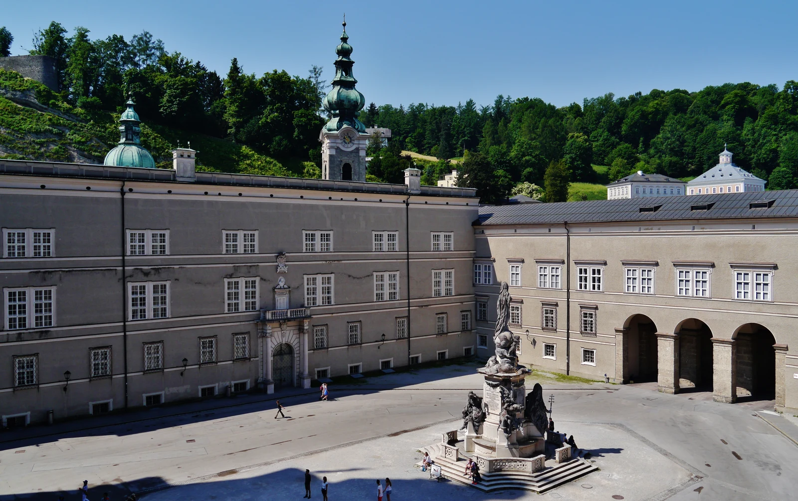 Sweeping view of the paved baroque Cathedral Square and facade in Salzburg.