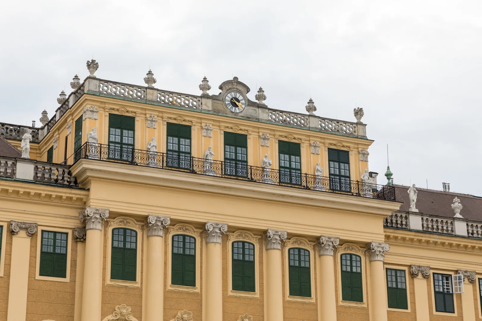Baroque ochre facade of Schönbrunn Palace with symmetrical formal garden parterres in Vienna.