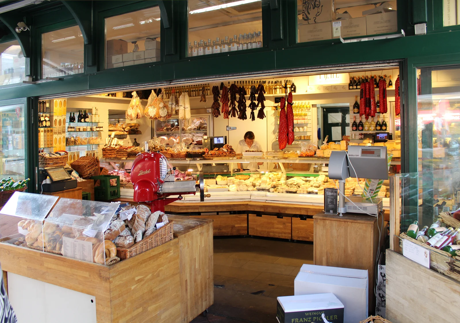 Row of traditional green municipal market stalls along an urban avenue.