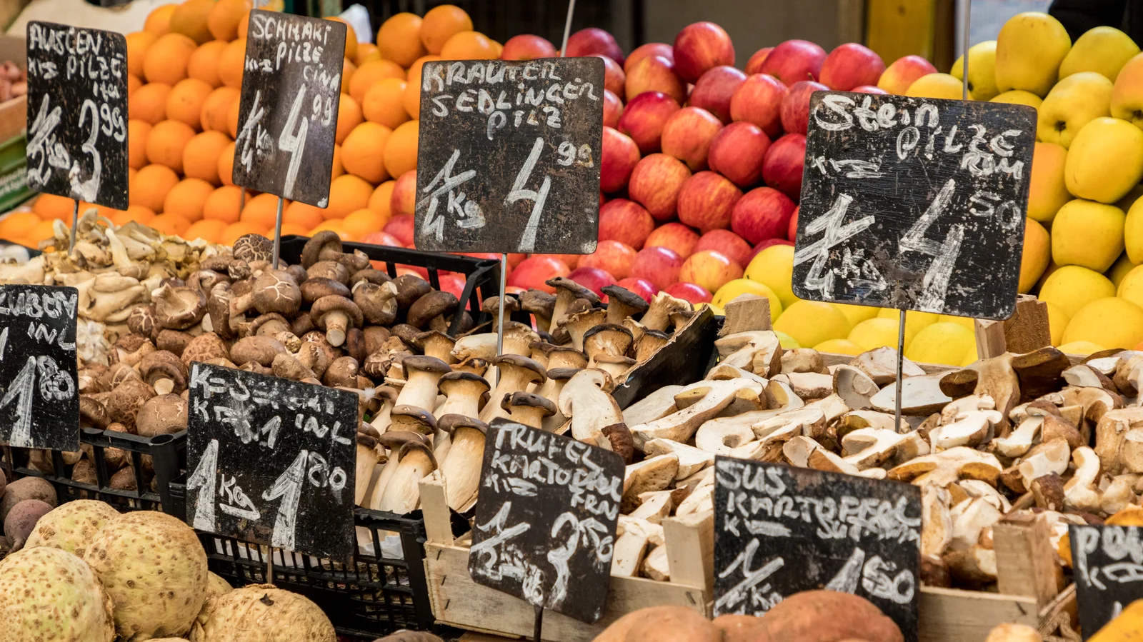 Panoramic view of open-air market stalls and surrounding historic Viennese architecture.