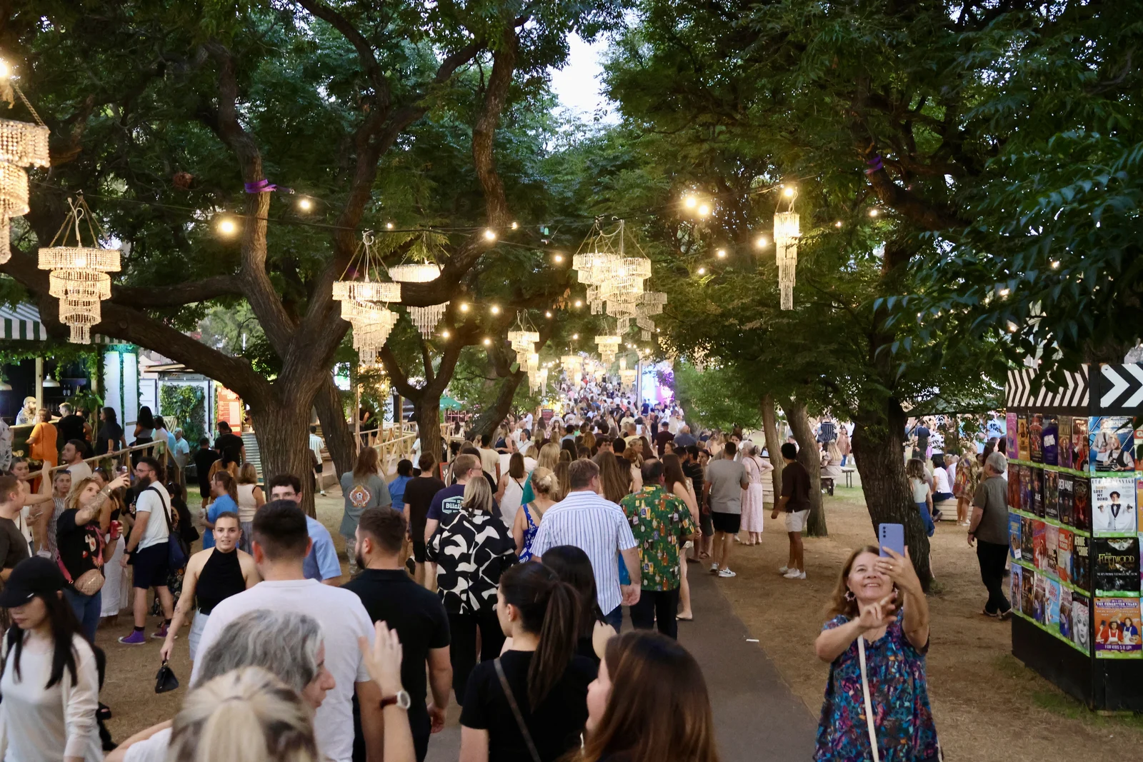 Festival crowds enjoying open-air dining and outdoor entertainment under evening lights in Adelaide parklands.