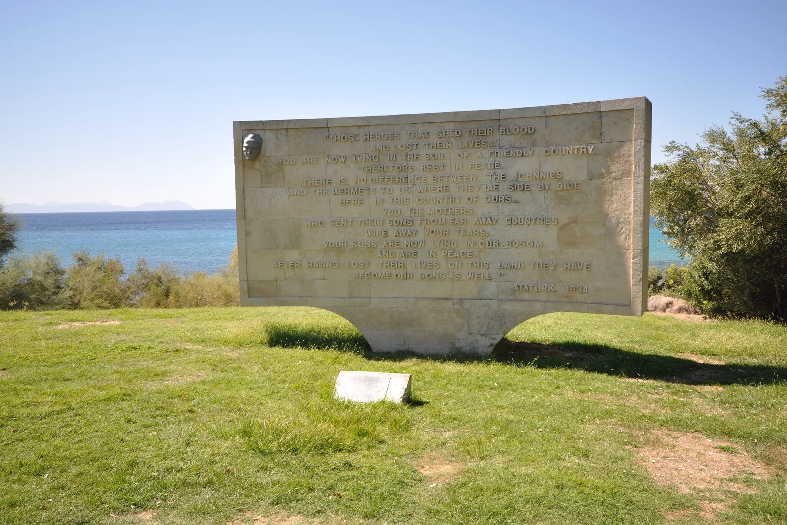 Rugged coastal cliffs and coastline of Anzac Cove at Gallipoli under blue sky.