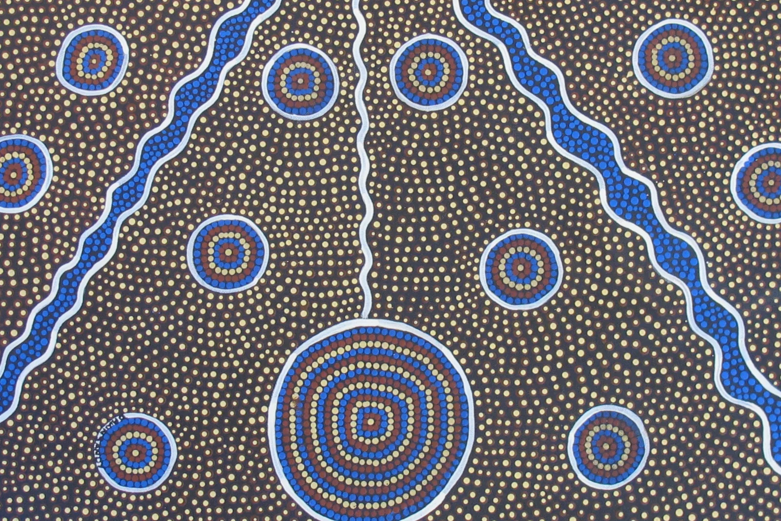Vibrant Australian Aboriginal dot painting on canvas with red, yellow, and white dotted motifs.