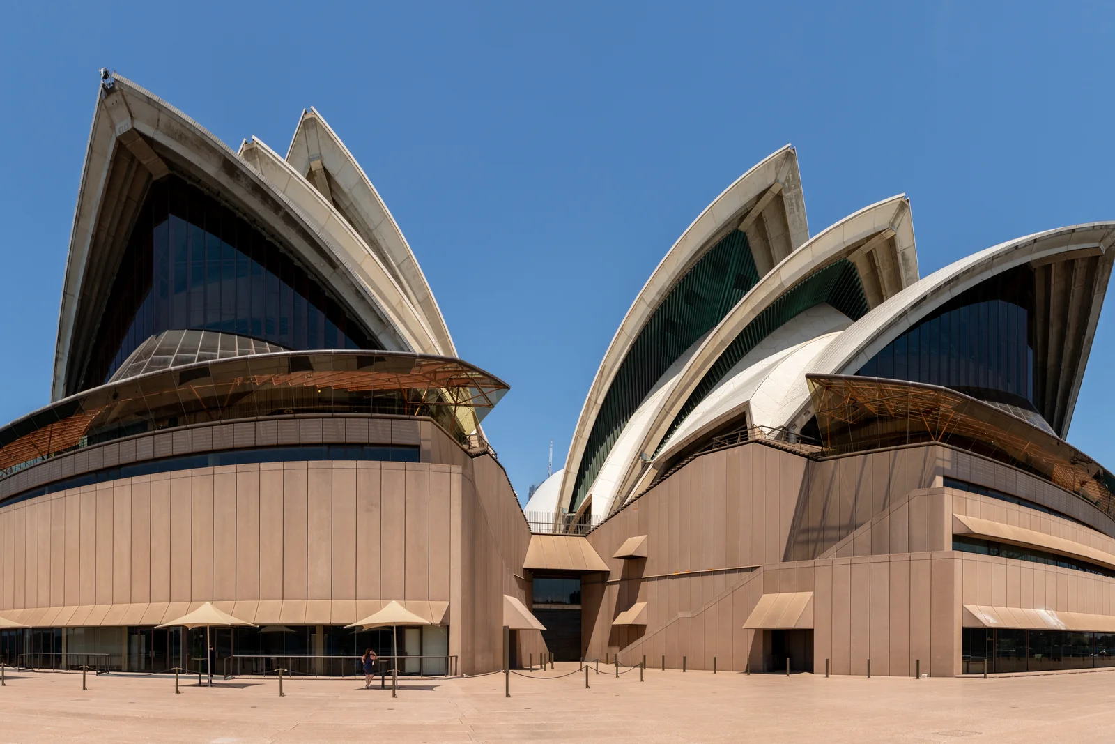 Sydney Opera House illuminated at twilight reflecting upon the waters of Sydney Harbour.