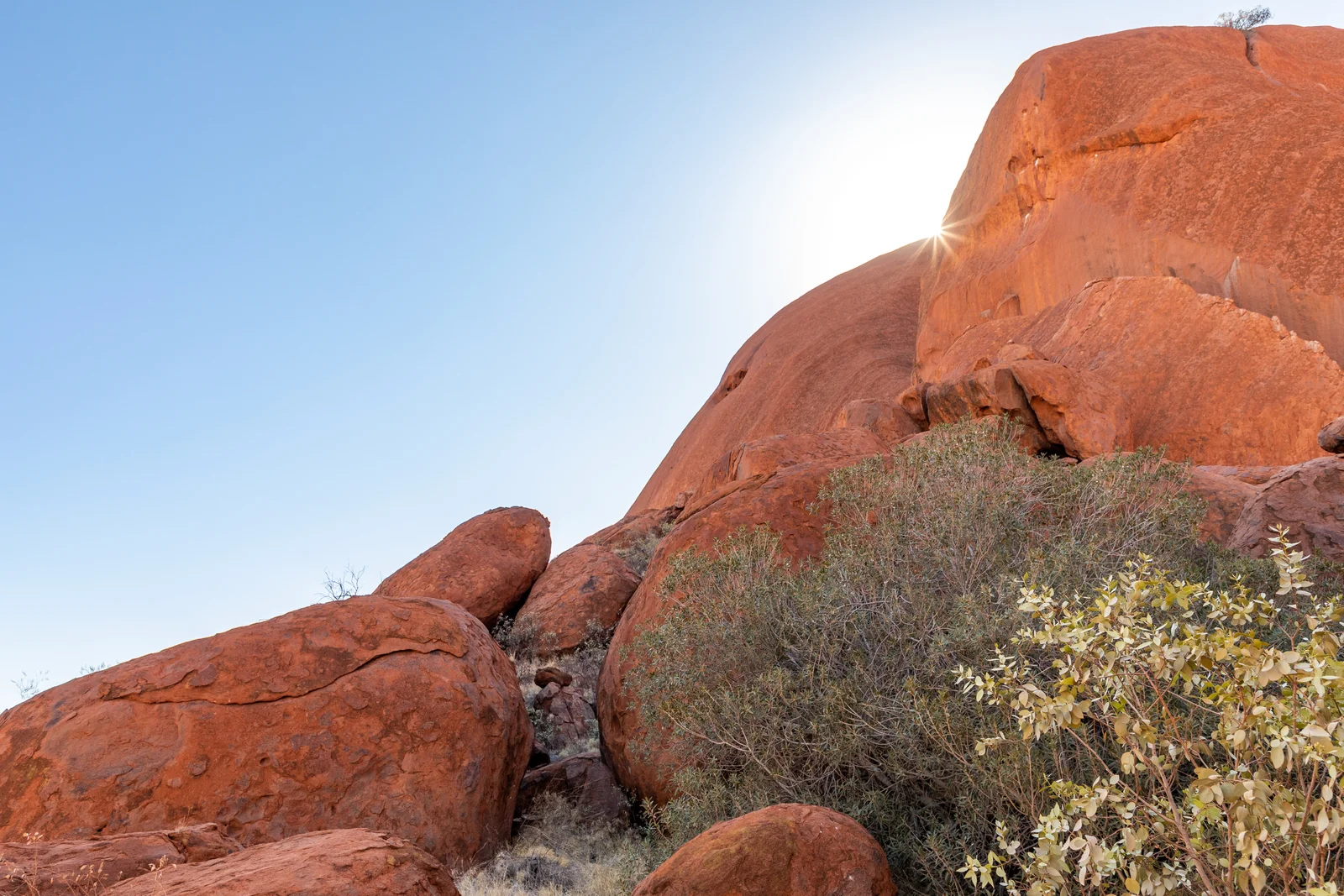 Close perspective of vertical sandstone fluting and weathered rock faces at the base of Uluru.