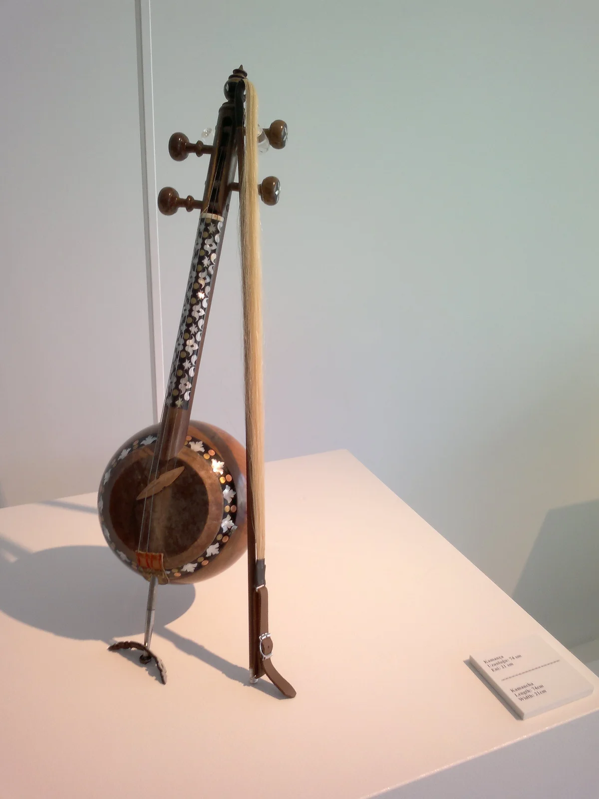 Traditional Azerbaijani kamancha spike fiddle displayed on an exhibition mount.