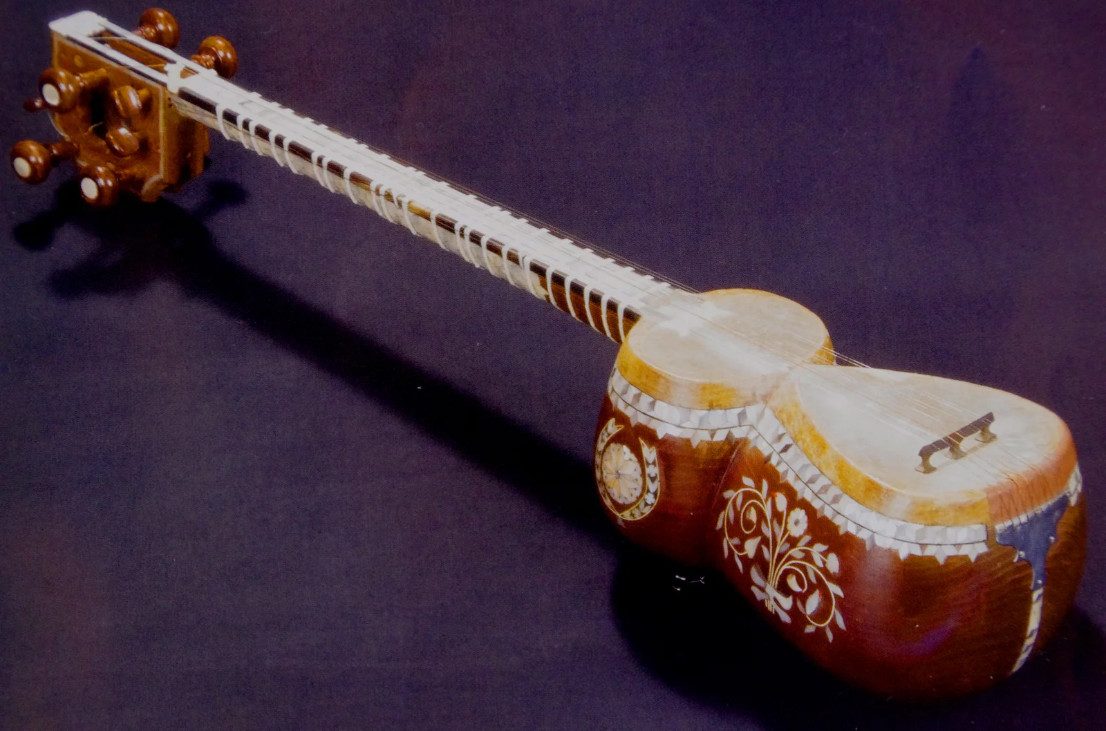 Detailed view of an Azerbaijani tar with carved wooden body and delicate mother-of-pearl inlays.