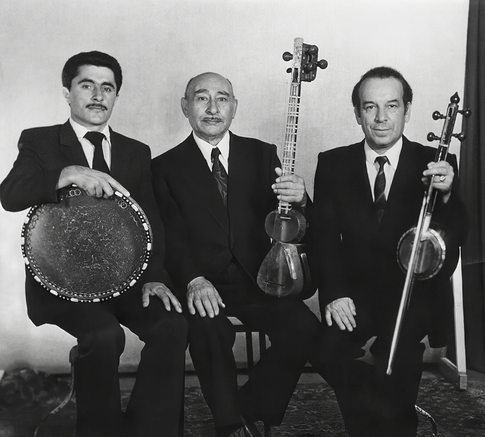 Three master Azerbaijani musicians performing together with traditional stringed instruments and vocals.