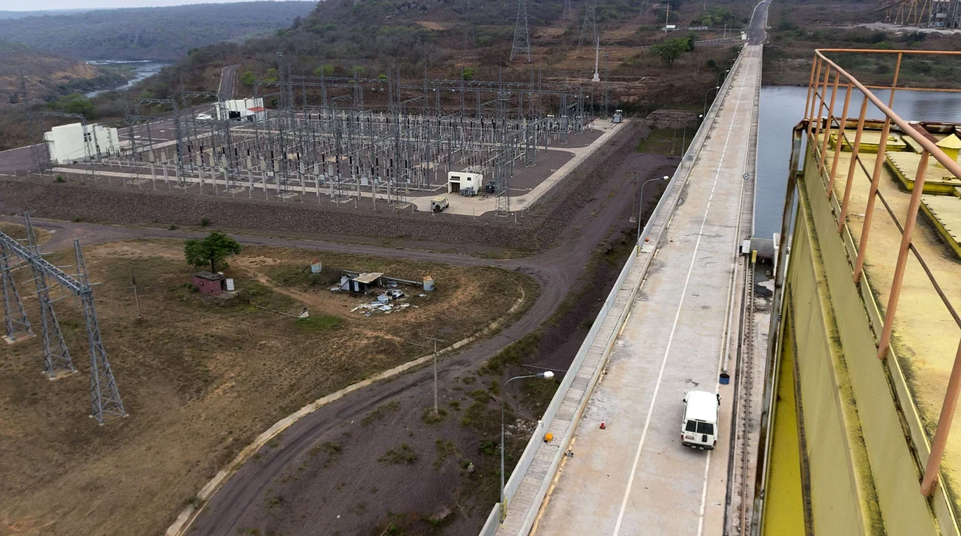 Electrical transformer banks, high-voltage insulators, and switchyard busbars under clear skies.