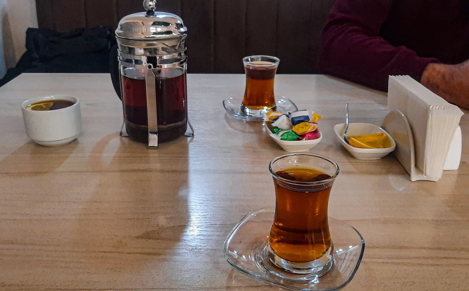 Tea service arrangement with multiple armudu glasses and saucers prepared for patrons at a traditional Azerbaijani tea room.