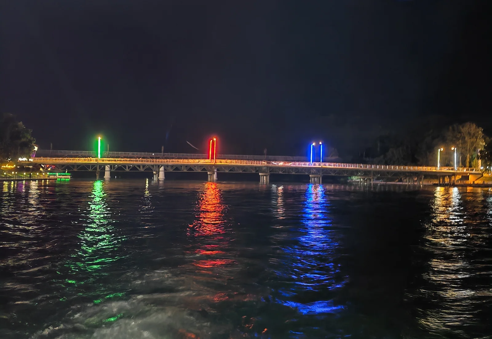 Wide river corridor with modern vehicular bridge spanning across calm green waters in Mingachevir.