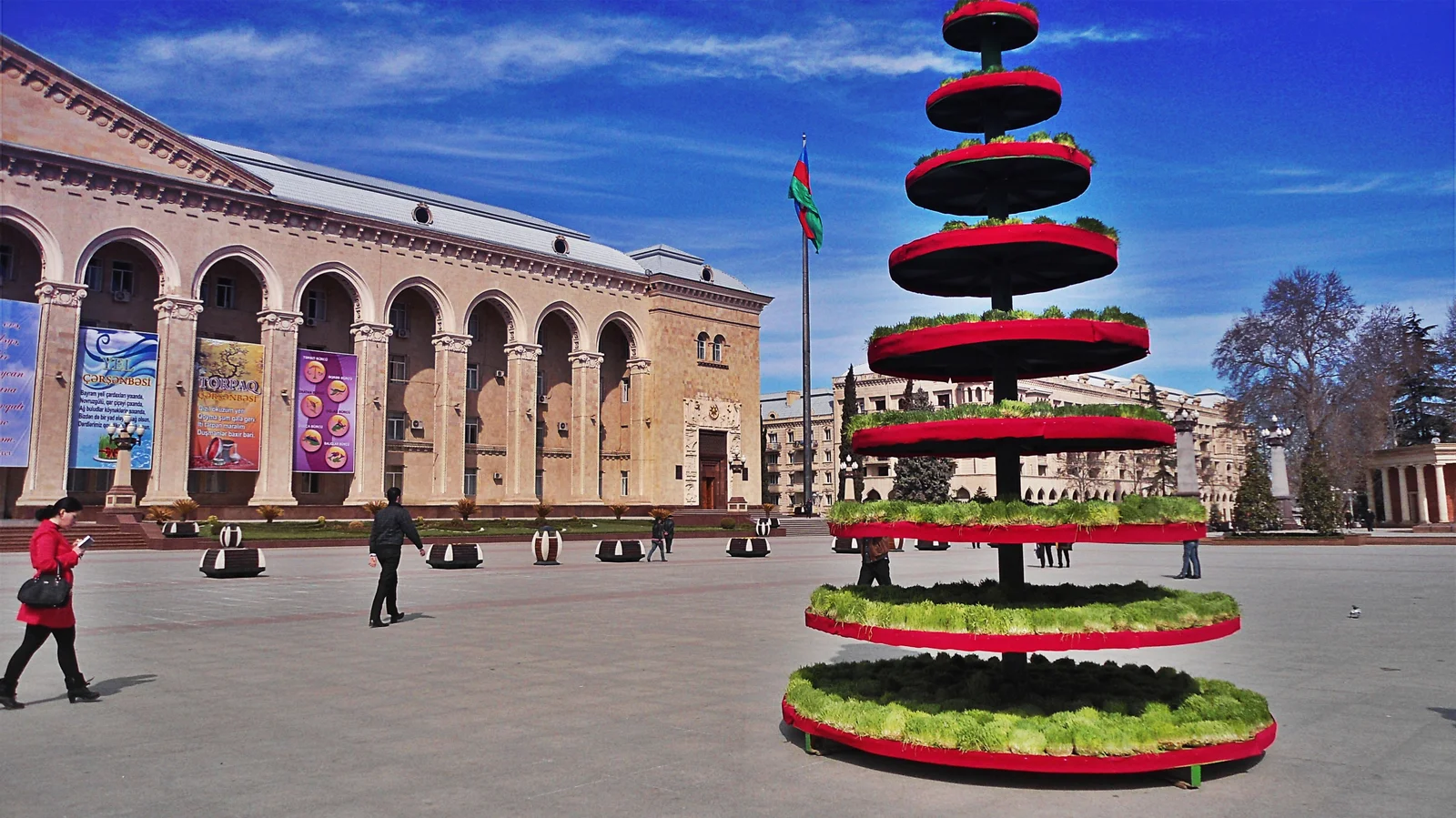 Outdoor regional holiday gathering with traditional tables, samani displays, and participants celebrating Novruz.