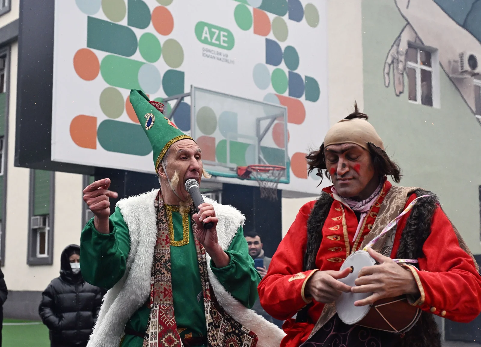 Costumed actors performing traditional comic Novruz folk sketches in vibrant historical clothing.