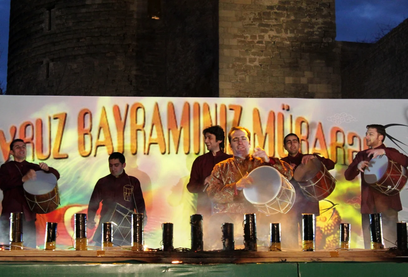 Traditional Azerbaijani percussion group performing on stage with naghara drums before a festival crowd.