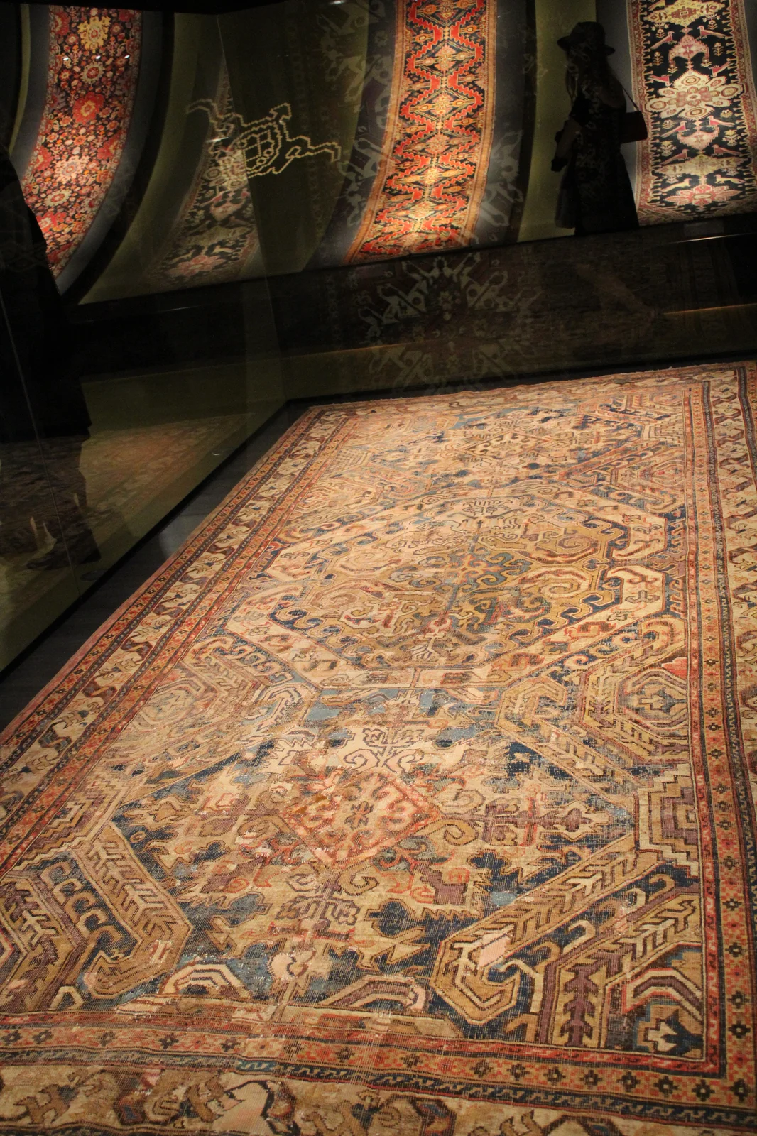 Intricately patterned antique wool carpet featuring stylized dragon palmettes and geometric medallions in red and blue.
