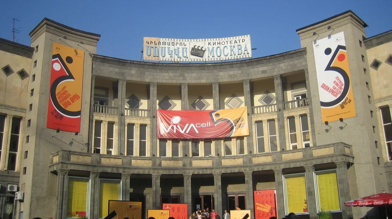 A grand neoclassical theatre building with illuminated facade and banner installations celebrating the winter arts festival.