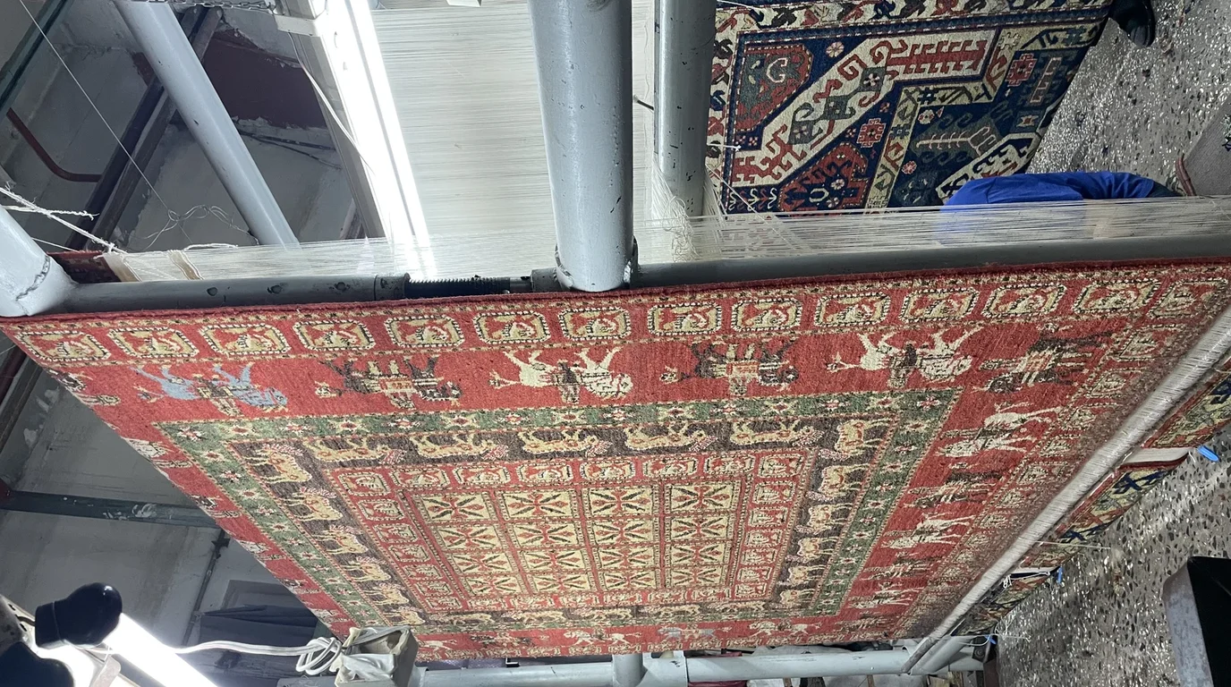 Artisan craft workshop where textile practitioners work together around tables surrounded by materials and heritage needlework.
