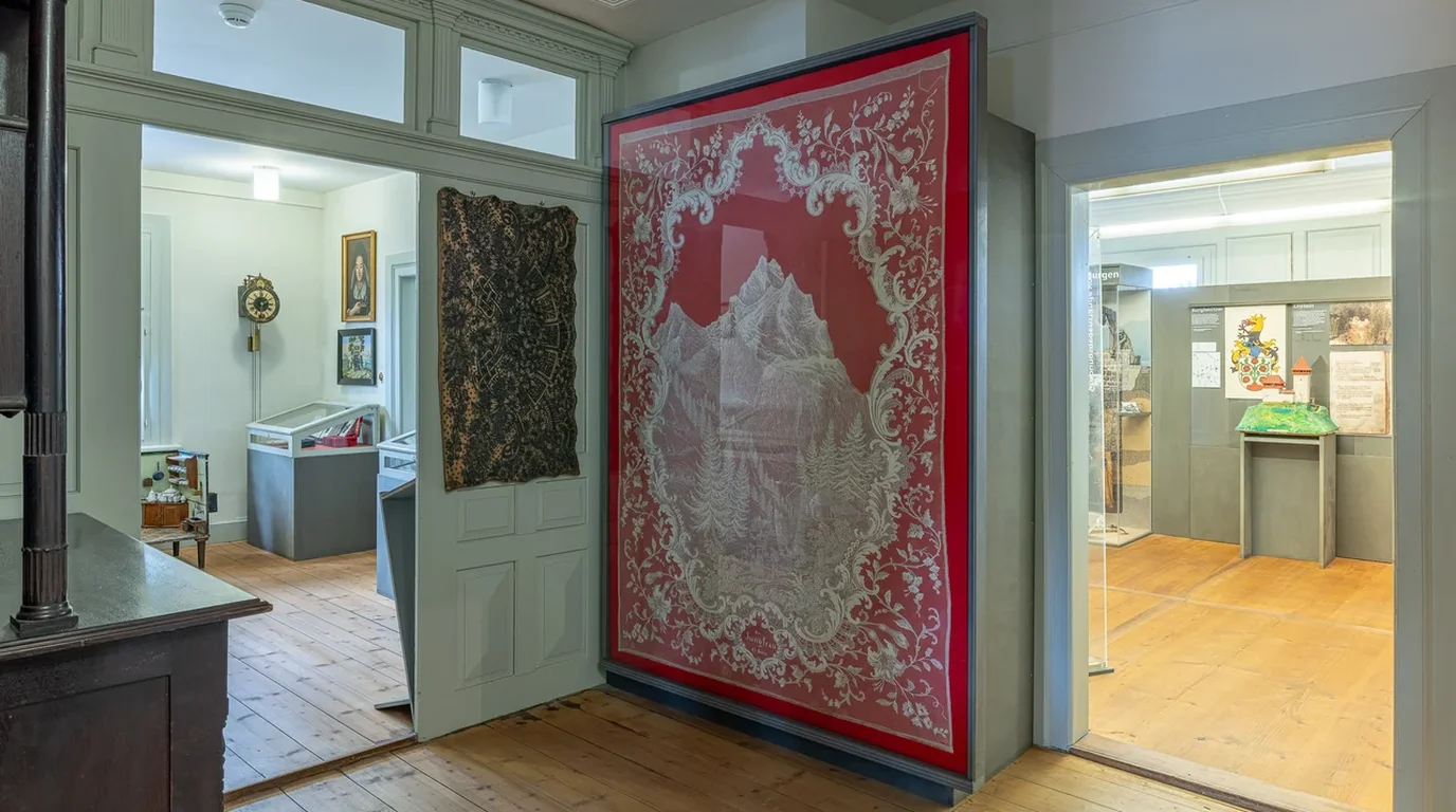 Textile museum archival showcase displaying traditional folk needlework samples with rhythmic repeating geometric ornamentations.