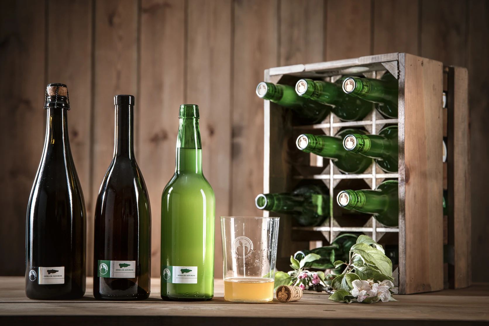 Certified green glass bottles bearing the Protected Designation of Origin Sidra de Asturias label.