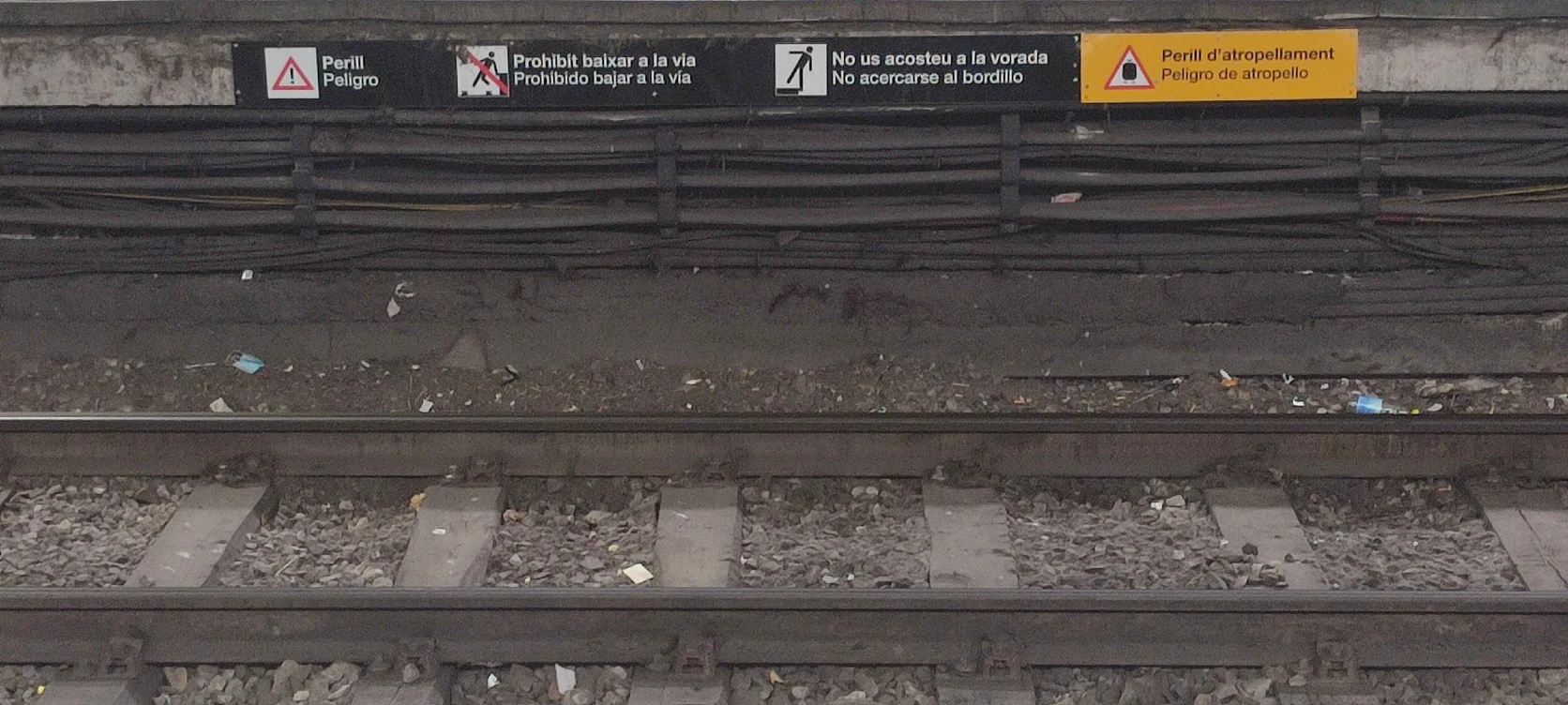 Bilingual platform wayfinding and trackside destination indicators in the Barcelona Metro.