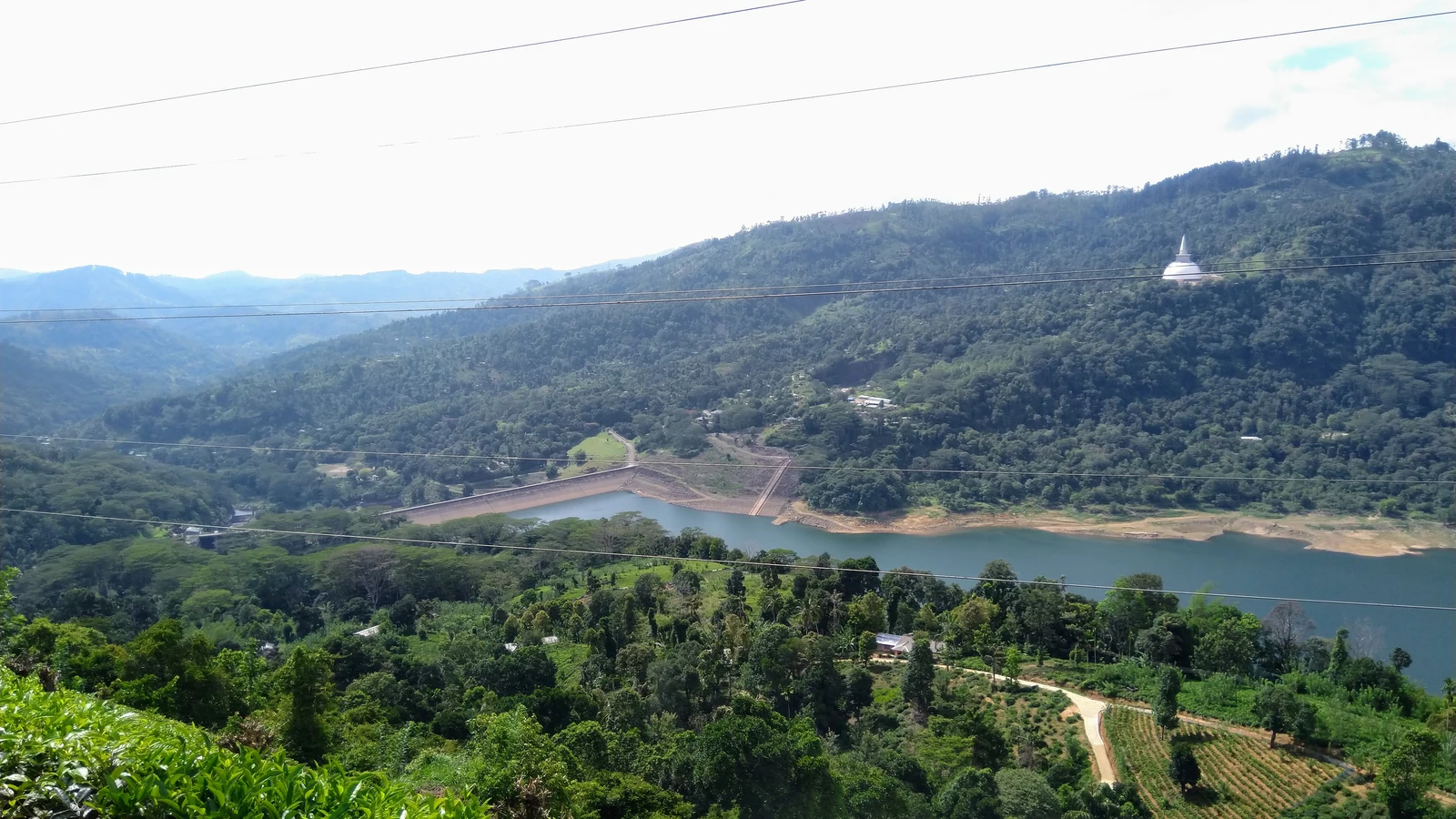 The deep blue waters of the Kotmale reservoir framed by mountain slopes in the Central Highlands.