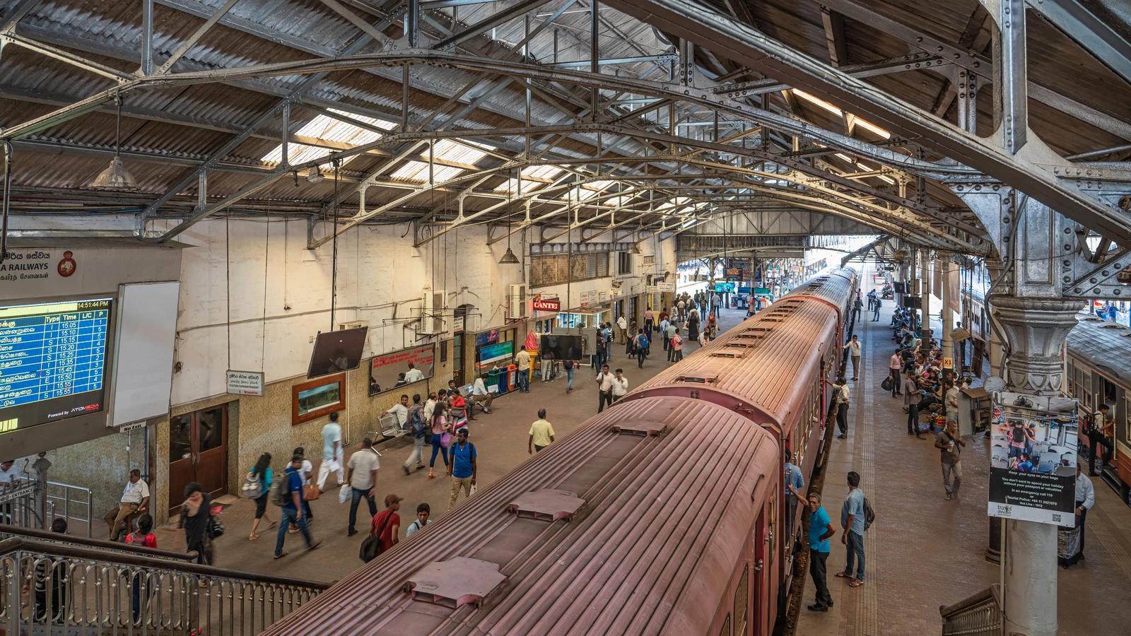 The neoclassical facade of Colombo Fort Railway Station bustling with daily morning commuters and buses.