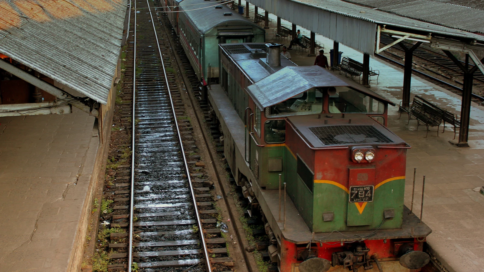 A diesel locomotive awaiting departure with passenger carriages along a platform at Colombo Fort.