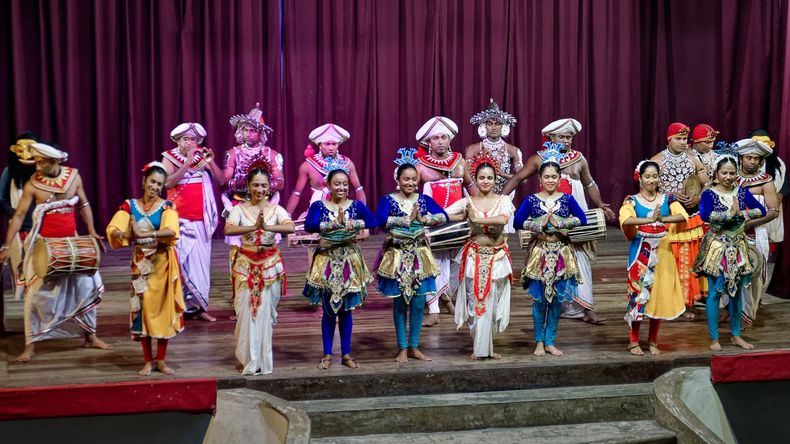 Energetic spinning jumps and dynamic stage choreography during a Kandyan cultural performance.