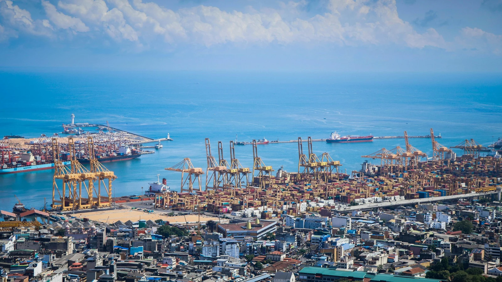 Aerial view of the Port of Colombo showing container terminals, breakwaters, and shipping channels.