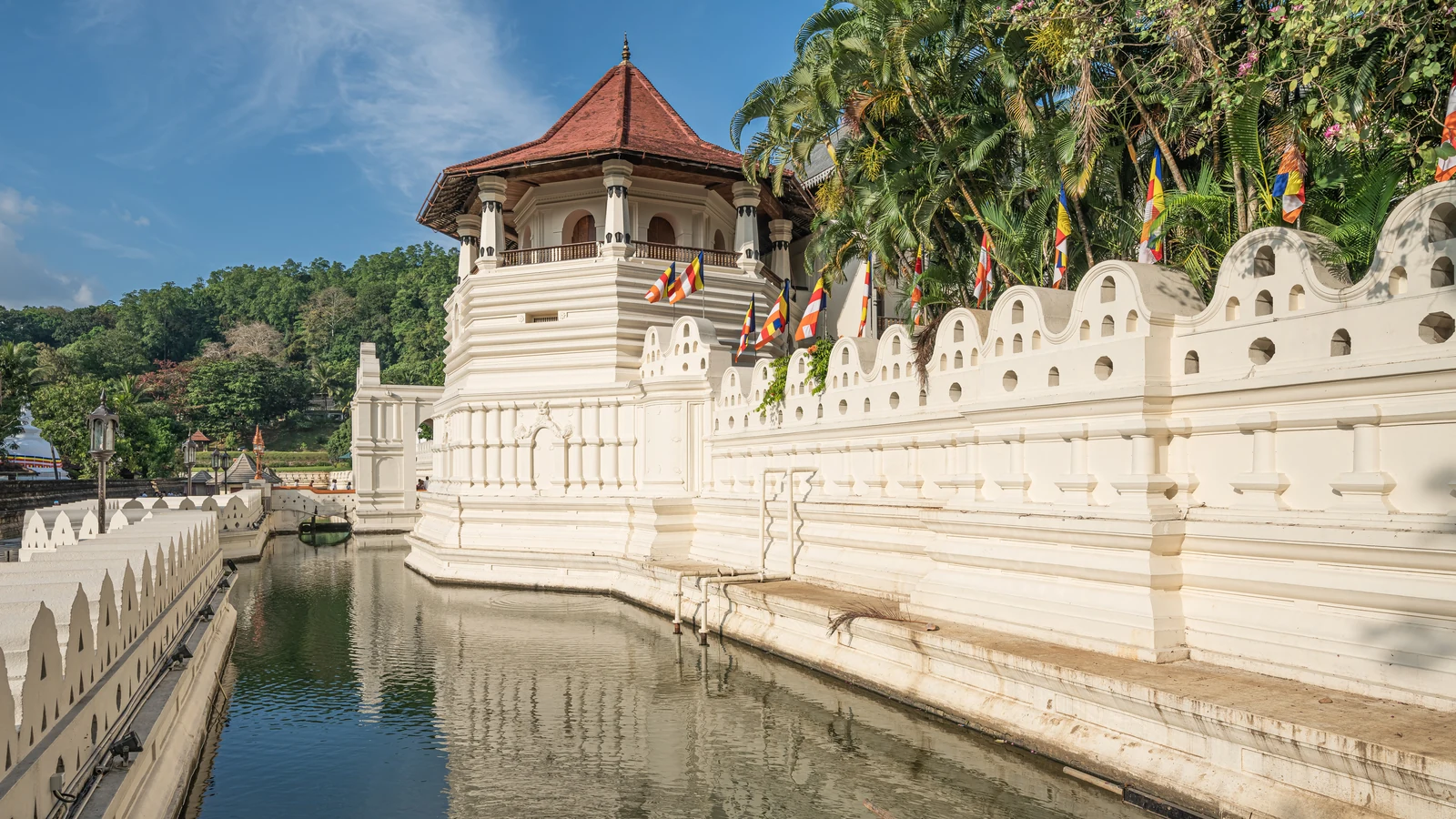 The Temple of the Sacred Tooth Relic complex and octagonal Paththirippuwa tower beside Kandy Lake.