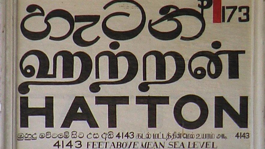 A railway station nameboard showing Hatton written in Sinhala, Tamil, and English scripts.