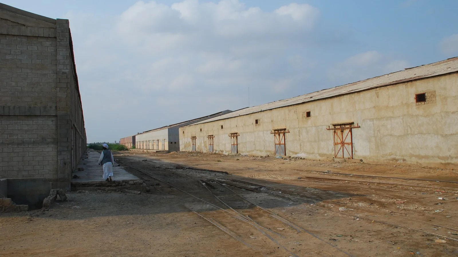 Massive masonry storage sheds and shaded freight bays in the Port Sudan harbour zone.