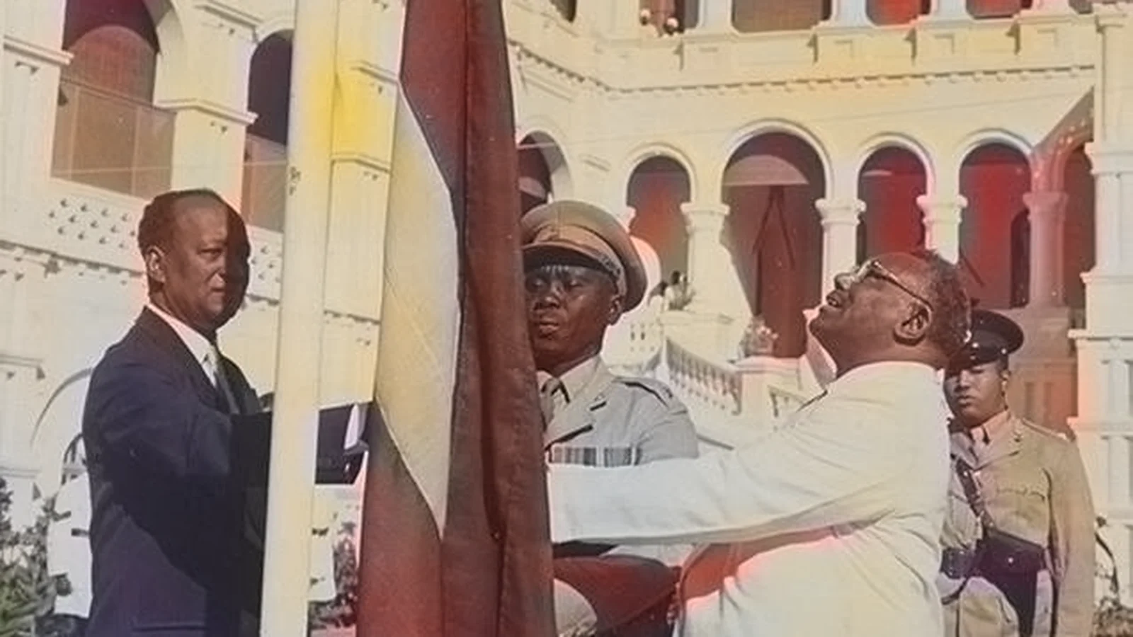 Historic photograph of the Sudanese national flag being raised at the Republican Palace in 1956.
