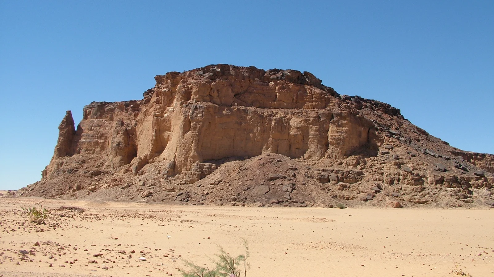 The sheer sandstone butte of Jebel Barkal rising above the desert sands near Karima, Northern State, Sudan.