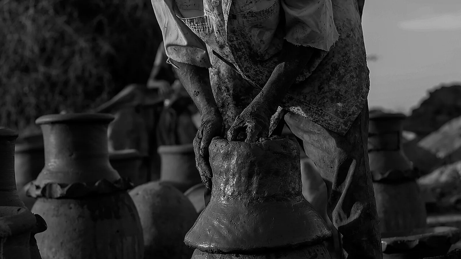 Artisan potter workshop shaping and firing porous earthenware water jars along the Nile basin.