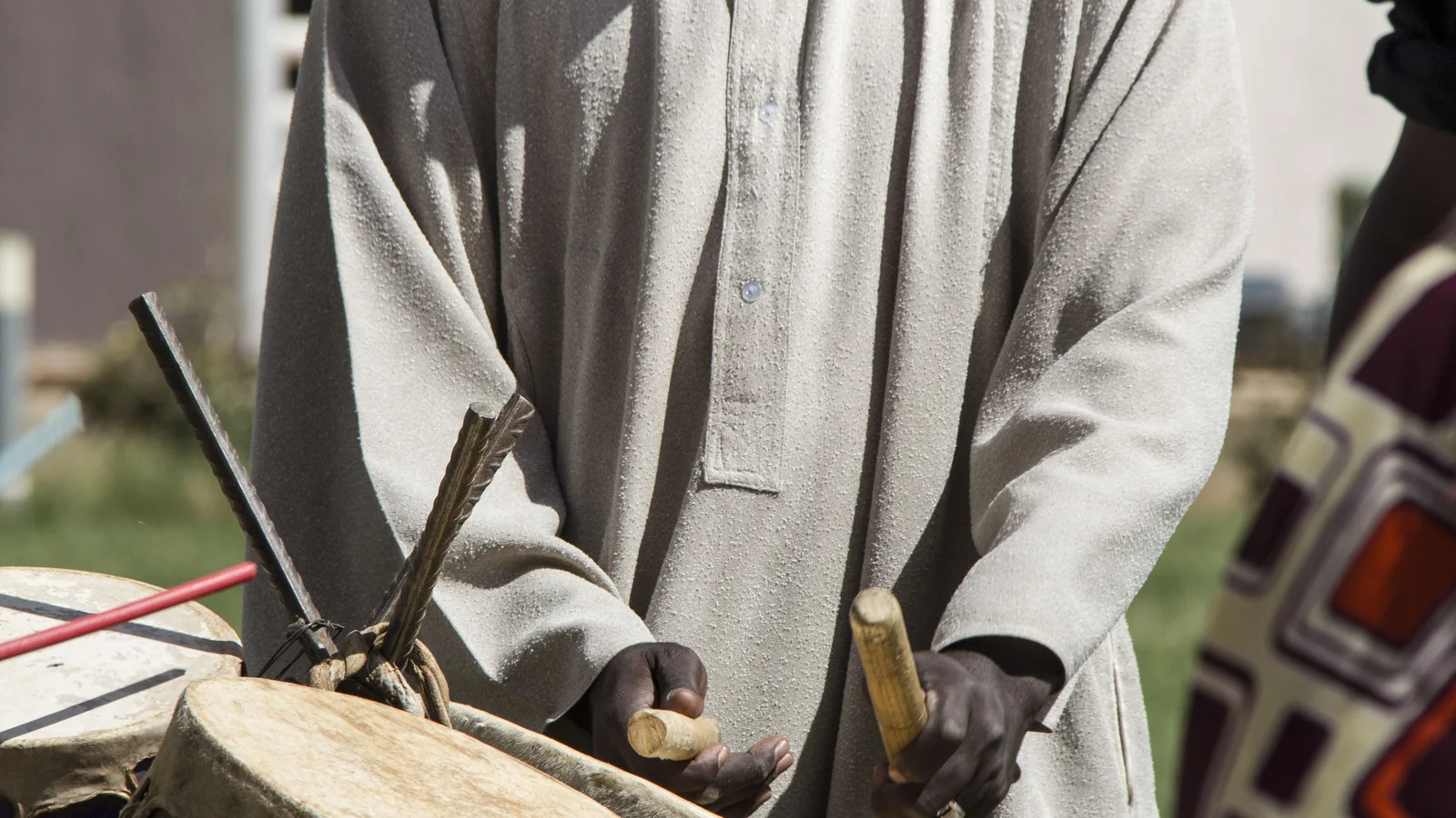 A musician performing on a Sudanese traditional stringed tambour instrument.