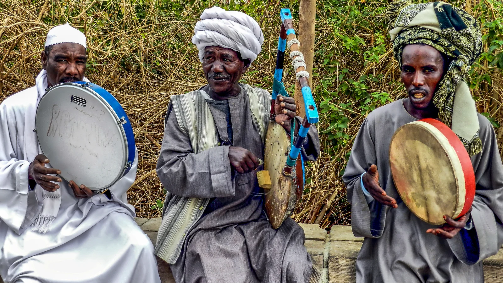 A traditional Nubian musical ensemble performing rhythmic vocal and percussion accompaniment in Sudan.
