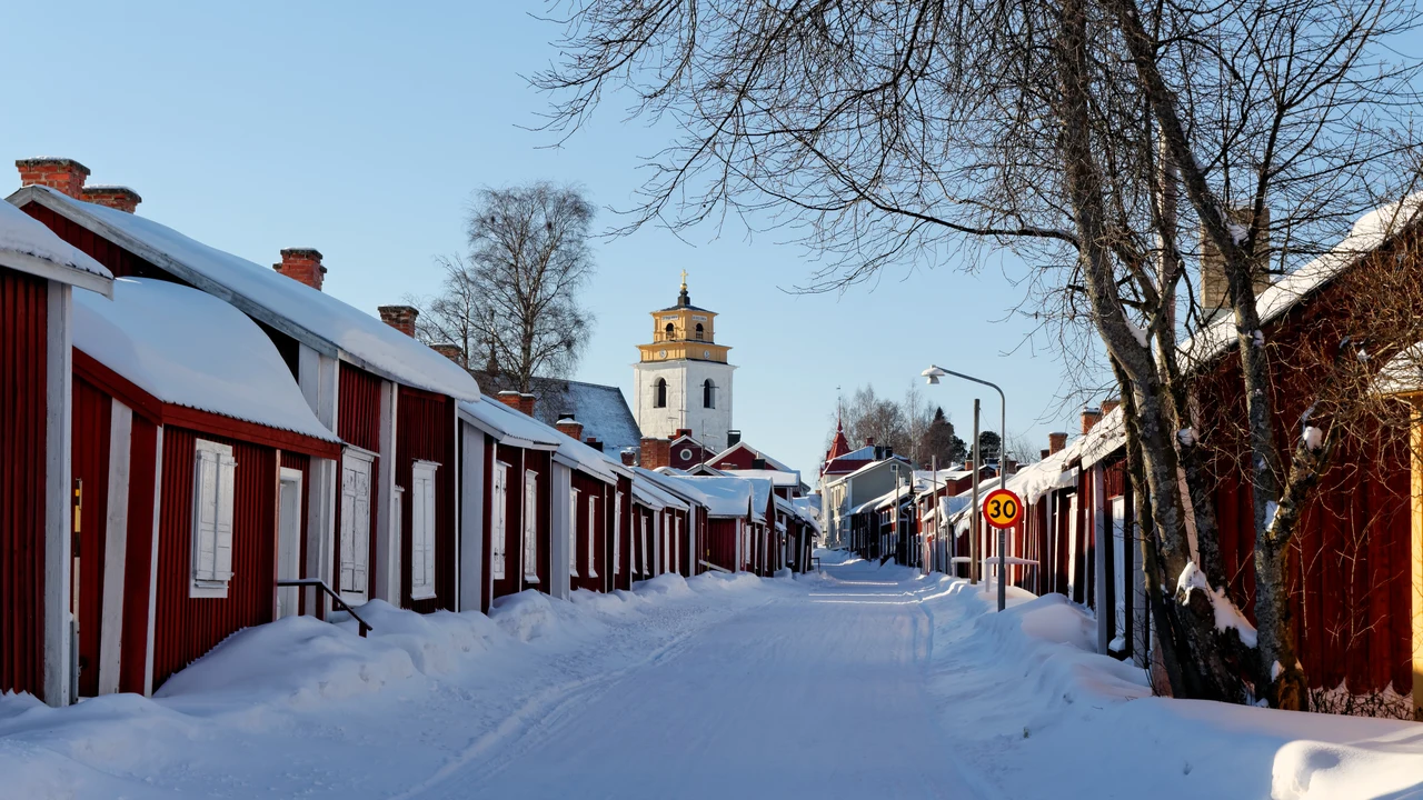 Overview of Gammelstad Church Town with red wooden cottages clustered around the medieval stone church in northern Sweden.