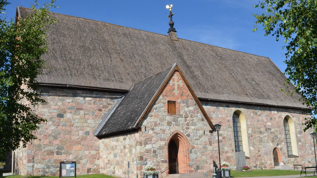 The imposing medieval stone facade and bell tower of Nederluleå Church in Gammelstad.
