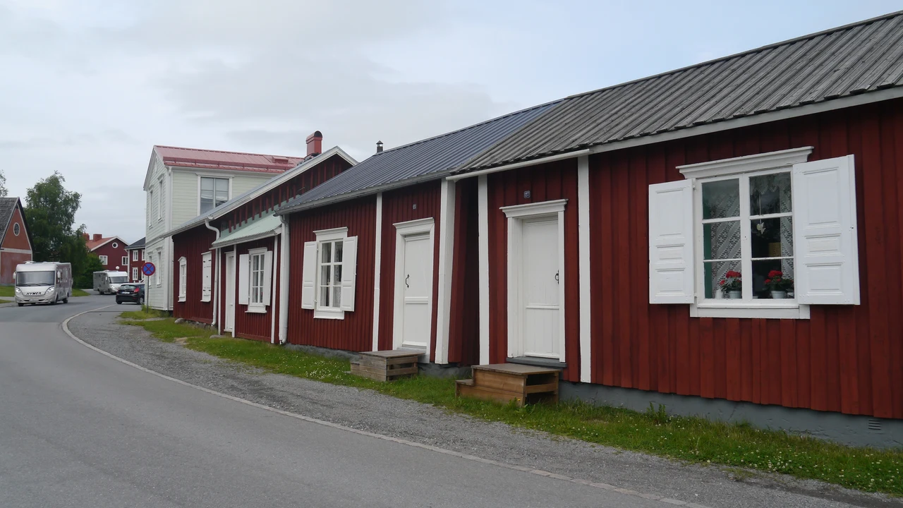 Narrow unpaved lane running between historic red wooden church cottages in Gammelstad.