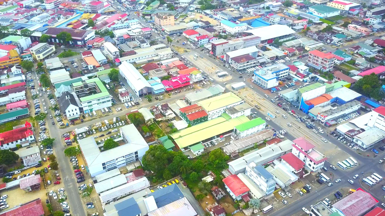 Commercial street corridor and thoroughfare in Paramaribo bustling with daily road traffic.
