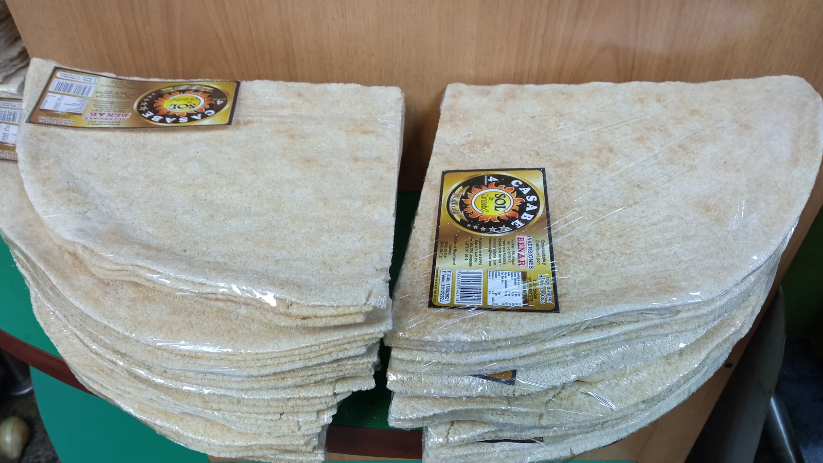 Stacks of crisp round cassava bread packaged in clear protective bundles for retail markets.