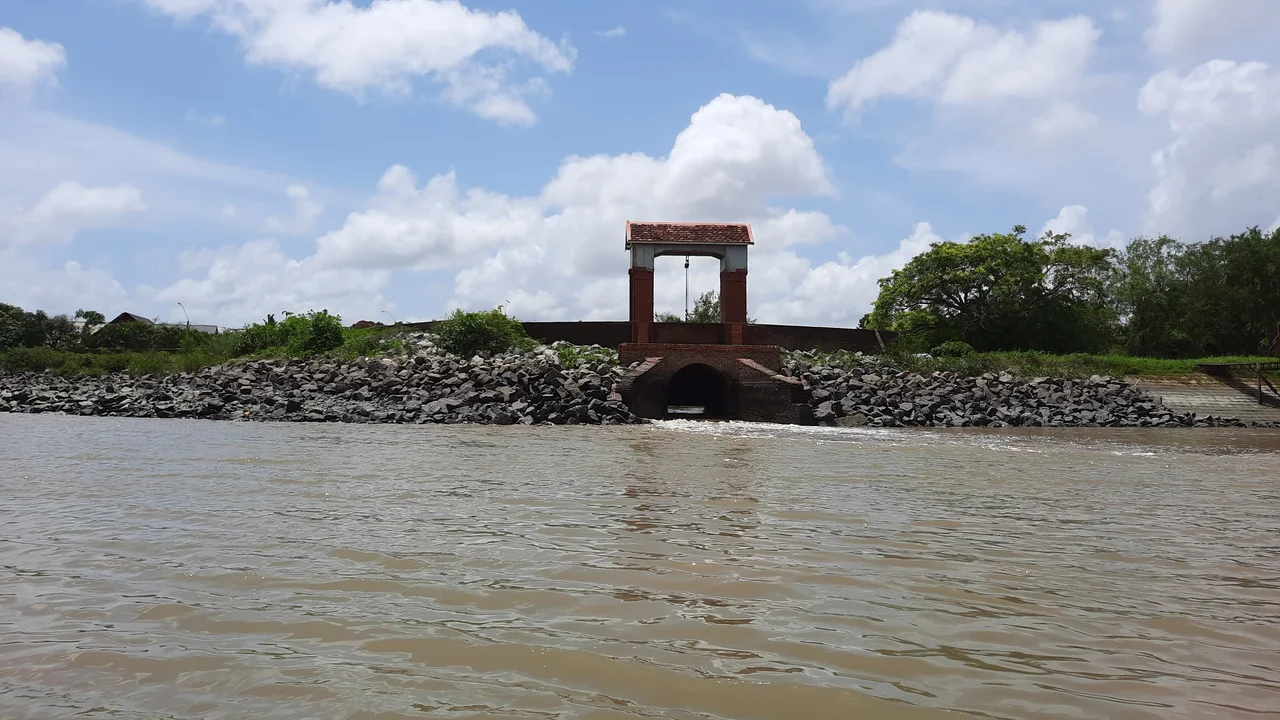 Reinforced sluice lock structure positioned along the riverbank drainage perimeter.