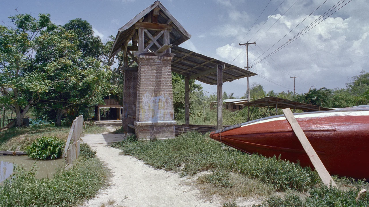 Historic brick and timber sluice gatehouse structure spanning an open drainage canal channel.