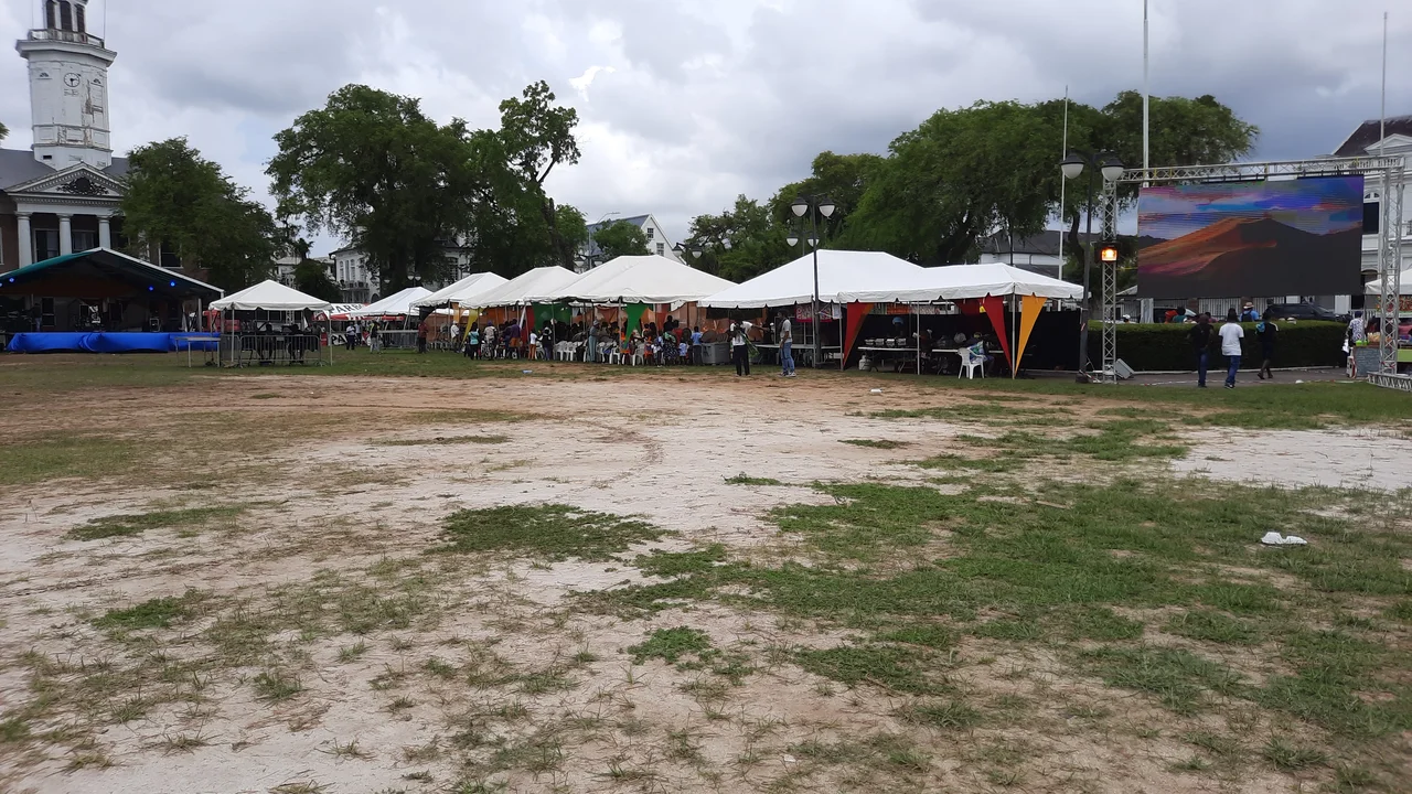 Celebrants and musicians in traditional woven attire participating in a public cultural festival in Paramaribo.